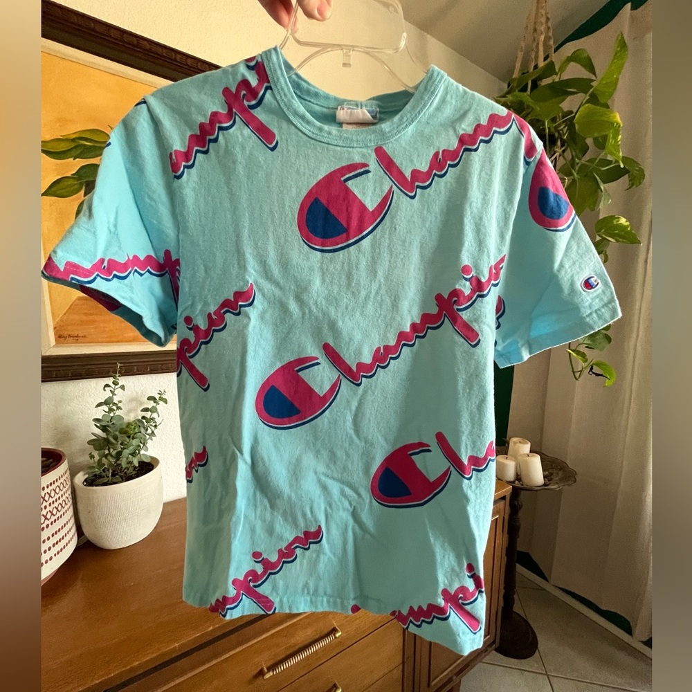 Champion Heritage Turquoise Graphic Tee with All-Over Pink and Blue Logo Print